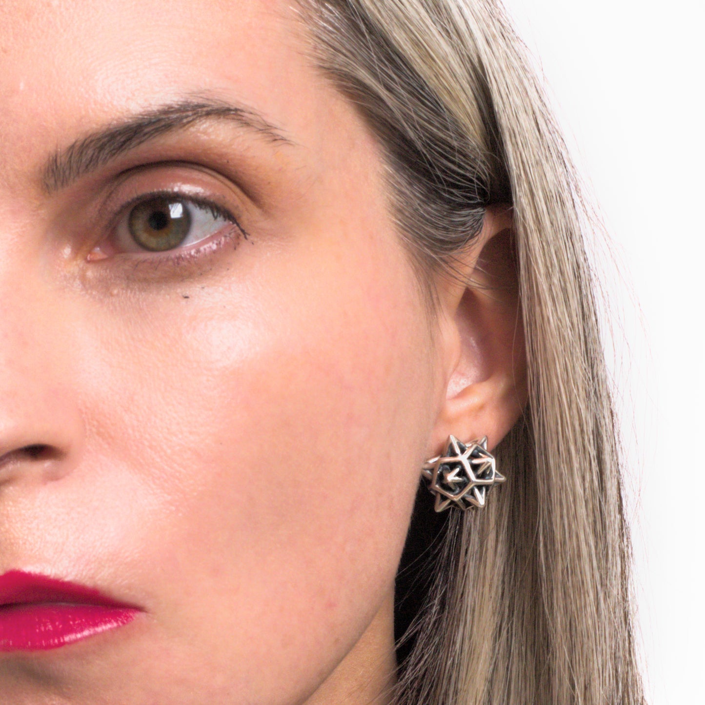 Contrast oxidized interlocking spike stud earrings in solid .925 sterling silver are shown styled on the ear for scale. They measure about 1/2 inch in diameter.