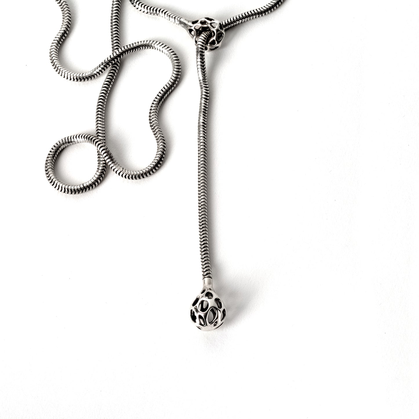 A sterling silver lariat necklace with a matching latticework droplet and cufflet hand-soldered to each end of a thick chunky snake chain. The bold sexy necklace drapes fluidly for a lightweight comfortable fit.