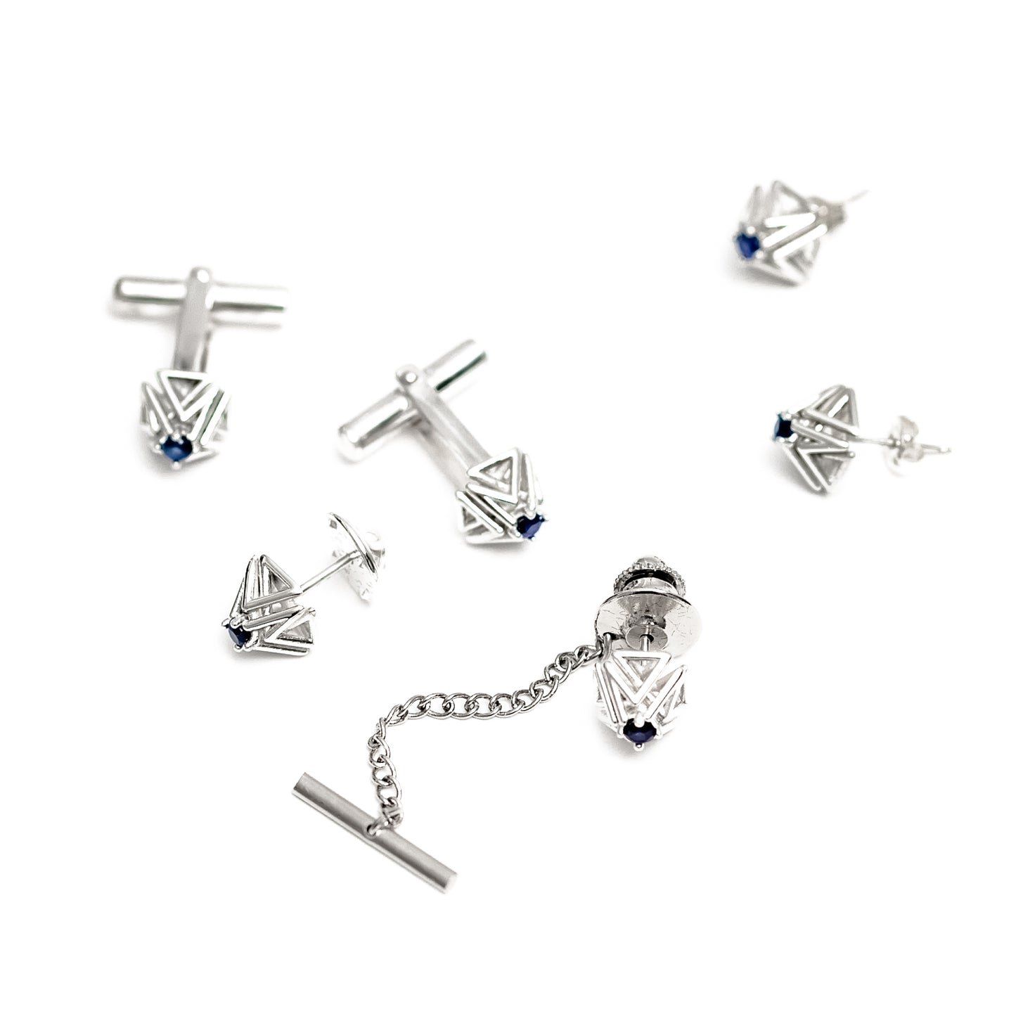This solid sterling silver and sapphire tie tack is part of a collection with matching cufflinks, and earrings, all shown here on a white background.