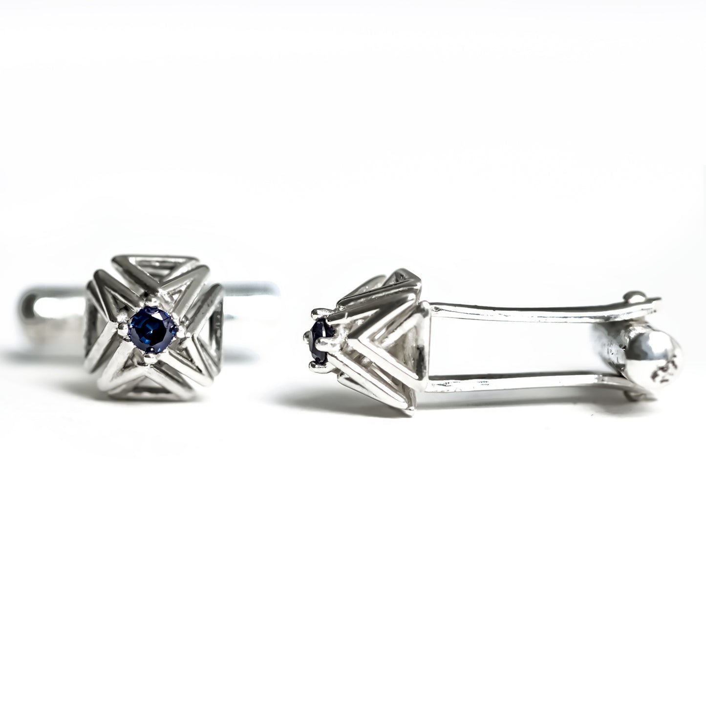 Blue sapphire and solid sterling silver cuff-links with toggle backs on a white background.