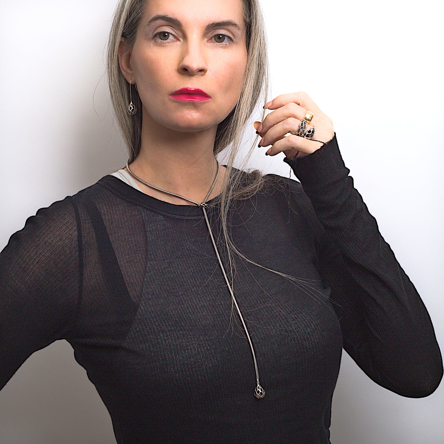 Xover0 Ovaline Collection of sterling silver sculptural jewelry. The set of matching, contrast oxidized long dangle earrings, ring, and lariat necklace are worn together with layered designer tops.