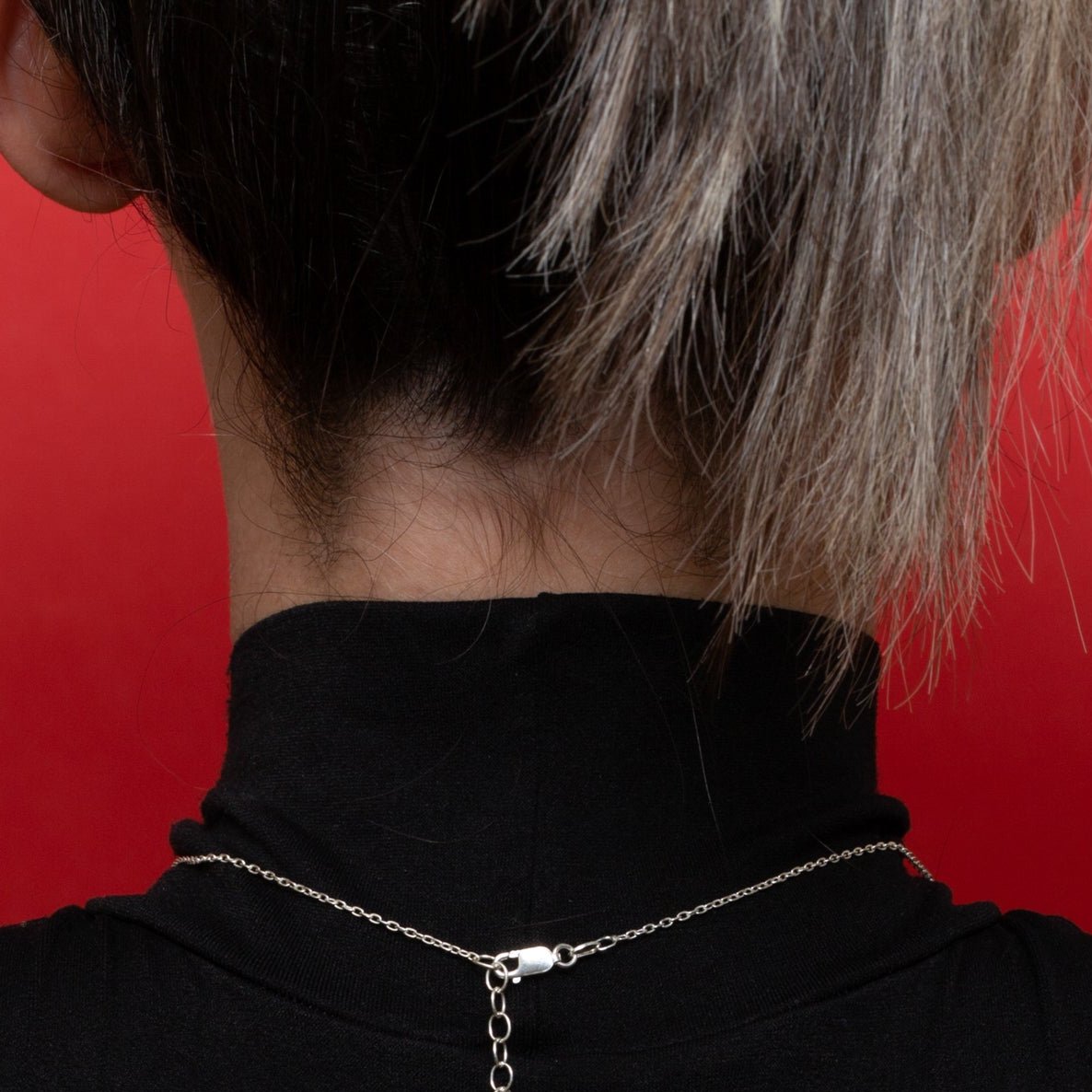 The back view of the Geoheart Pendant necklace highlights the adjustable chain designed for the solid 18 karat white and yellow gold versions. (The .925 sterling silver option features a slider mechanism for customizable lengths.) Each necklace is finished with a sturdy lobster clasp, reflecting Xover0 Jewelry's commitment to quality and durability, which can be seen in the Netflix movie Uglies, worn by Joey King as the adventurous Tally Youngblood.