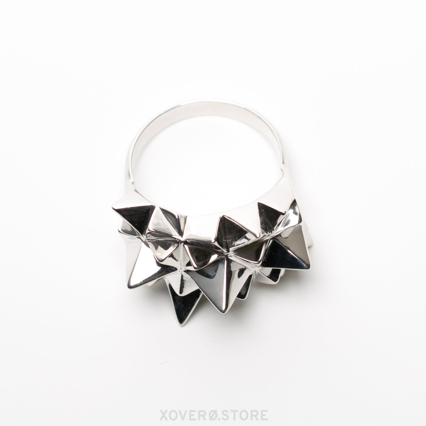 Side view of an heirloom sterling silver, spike covered statement ring, with a dramatic mirror shine reflecting light and shadow from every angle.