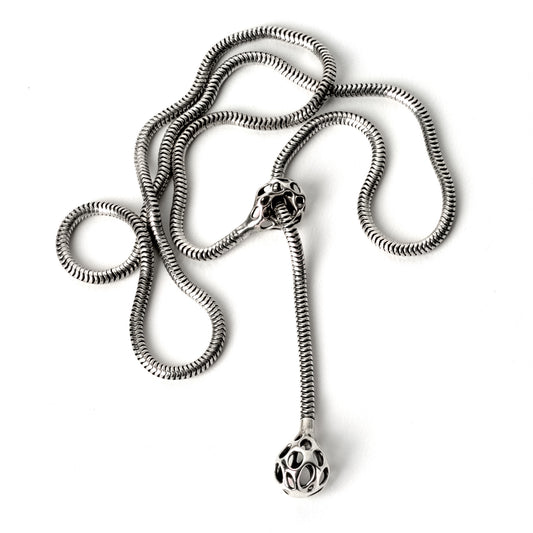 A chunky sterling silver lariat necklace with a snake chain connecting a latticework droplet and matching cufflet for an adjustable comfortable fit. 