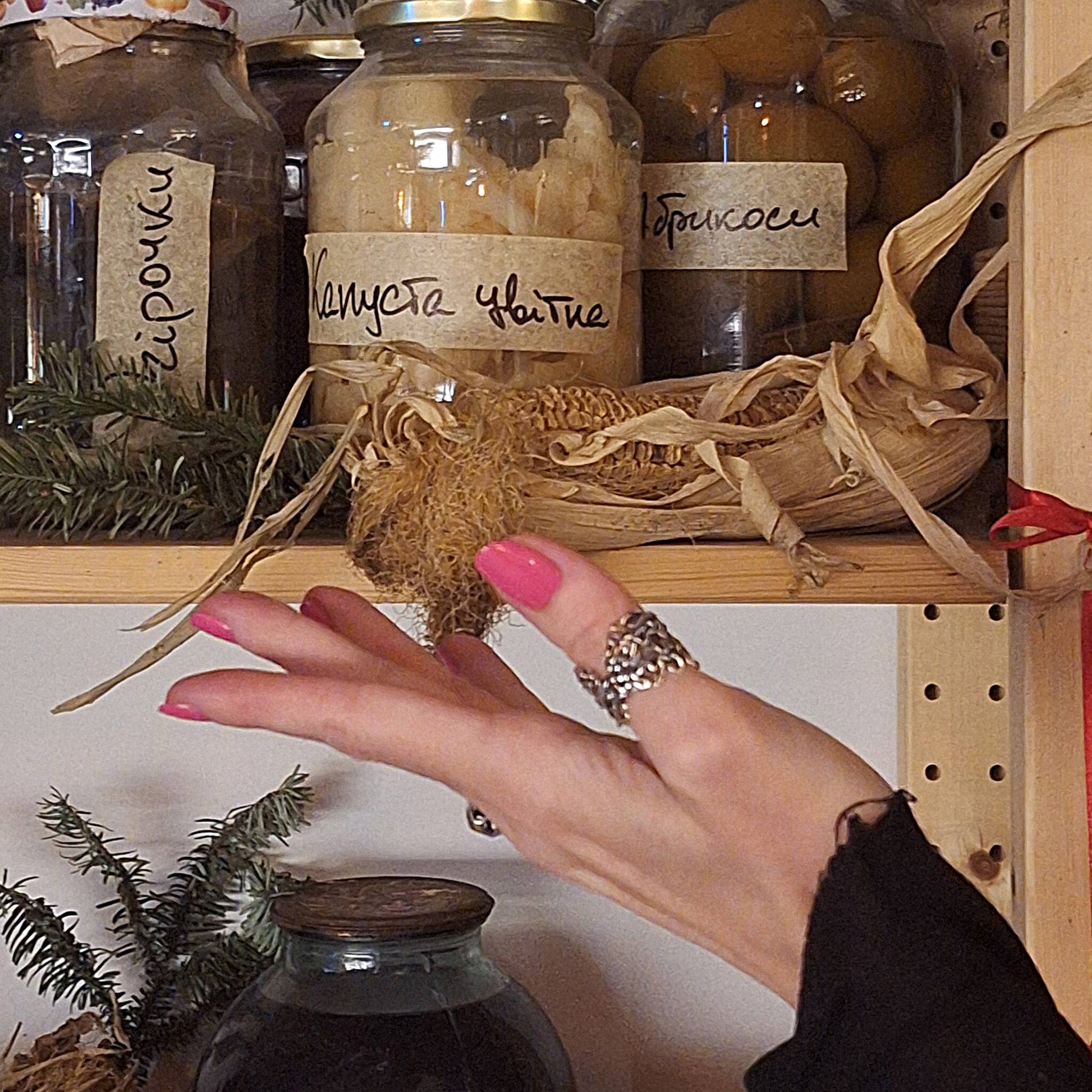 Sterling silver thumb ring with Mississippi River design worn on hand displaying jars of pickles. 