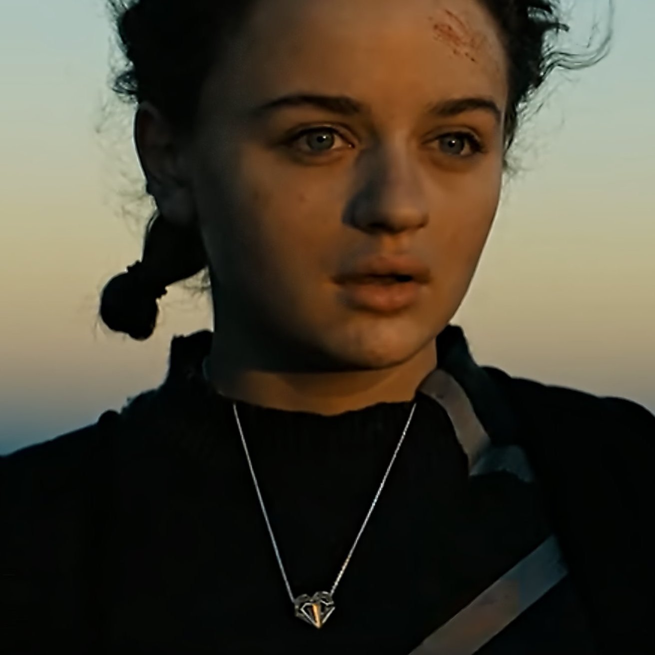 A close-up of the solid sterling silver Geoheart Pendant Necklace featured in Netflix's Uglies. In this scene, worn by Tally Youngblood (Joey King), the highly polished heart pendant captures hues from the surrounding sunrise, reflecting them beautifully back at the viewer.