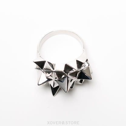 Side view of an heirloom sterling silver, spike covered statement ring, with a dramatic mirror shine reflecting light and shadow from every angle. 